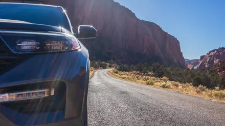 Auto fährt auf einer langen Straße durch typische USA-Landschaft