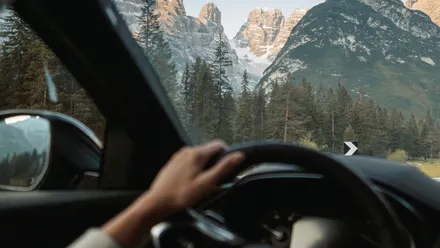 Blick aus dem Auto auf eine Straße mit Berglandschaft während der Fahrt