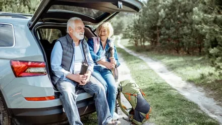 Älteres Paar macht Pause an einem Mietwagen nach einem Ausflug in die Natur