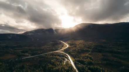 Straße auf den Lofoten im Sonnenlicht unter beeindruckendem Wolkenspiel