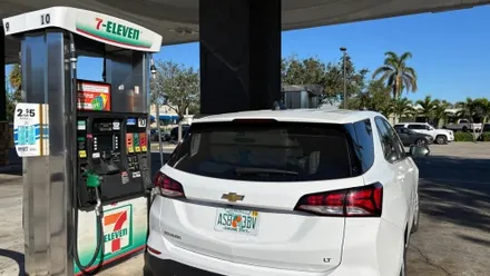 Weißes Auto steht an einer Zapfsäule einer 7-Eleven-Tankstelle