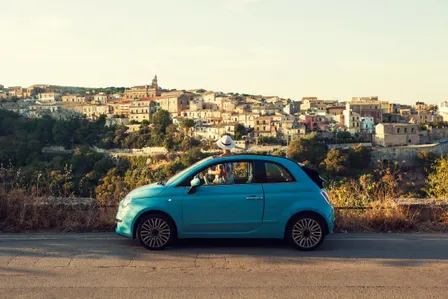 blaues Auto auf Strasse vor Stadt