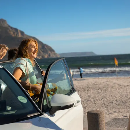 Vrouw stapt uit auto bij strand
