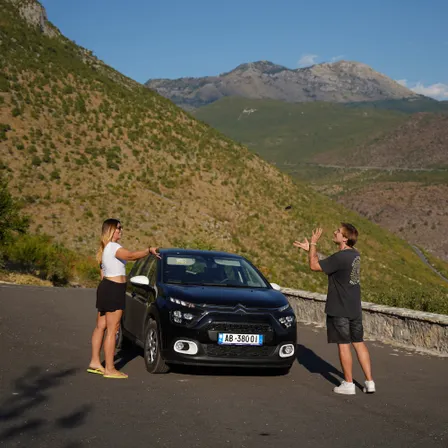 Reisende machen eine Pause mit dem Mietwagen auf einer Bergstraße in Albanien