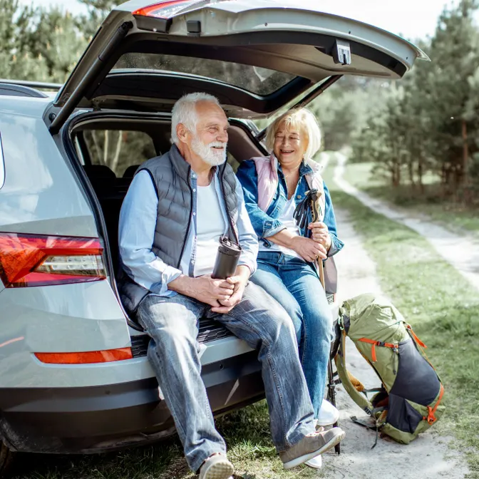 Älteres Paar macht Pause an einem Mietwagen nach einem Ausflug in die Natur