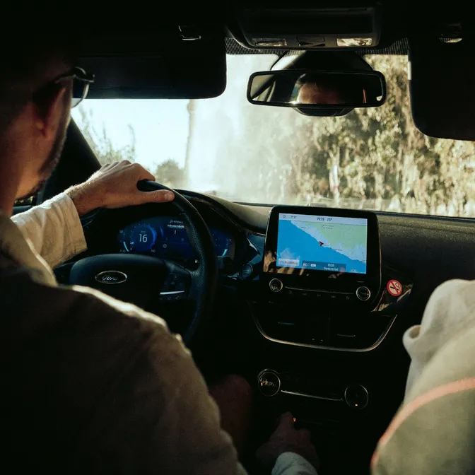 Mann sitzt am Steuer, navigiert dank GPS