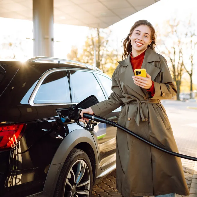 Frau tankt ihren Mietwagen an der Tankstelle